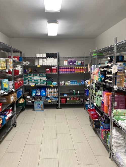 Photograph of a room full of shelves containing food and household supplies.