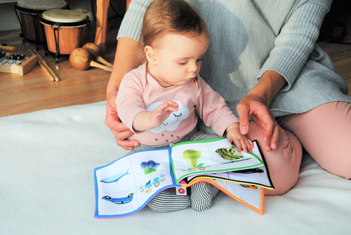 A young child looking at a cloth picture book.