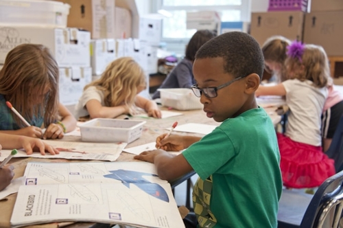 Children at their desks working on workbook